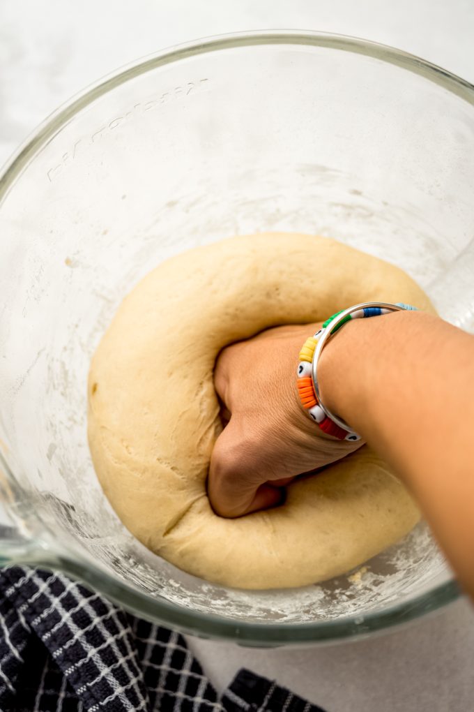 Someone is using their fist to punch down yeasted dough.