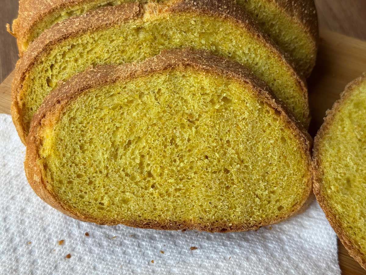 Chewy yeast corn bread or crusty corn flour cornbread, sliced to show yellow color.
