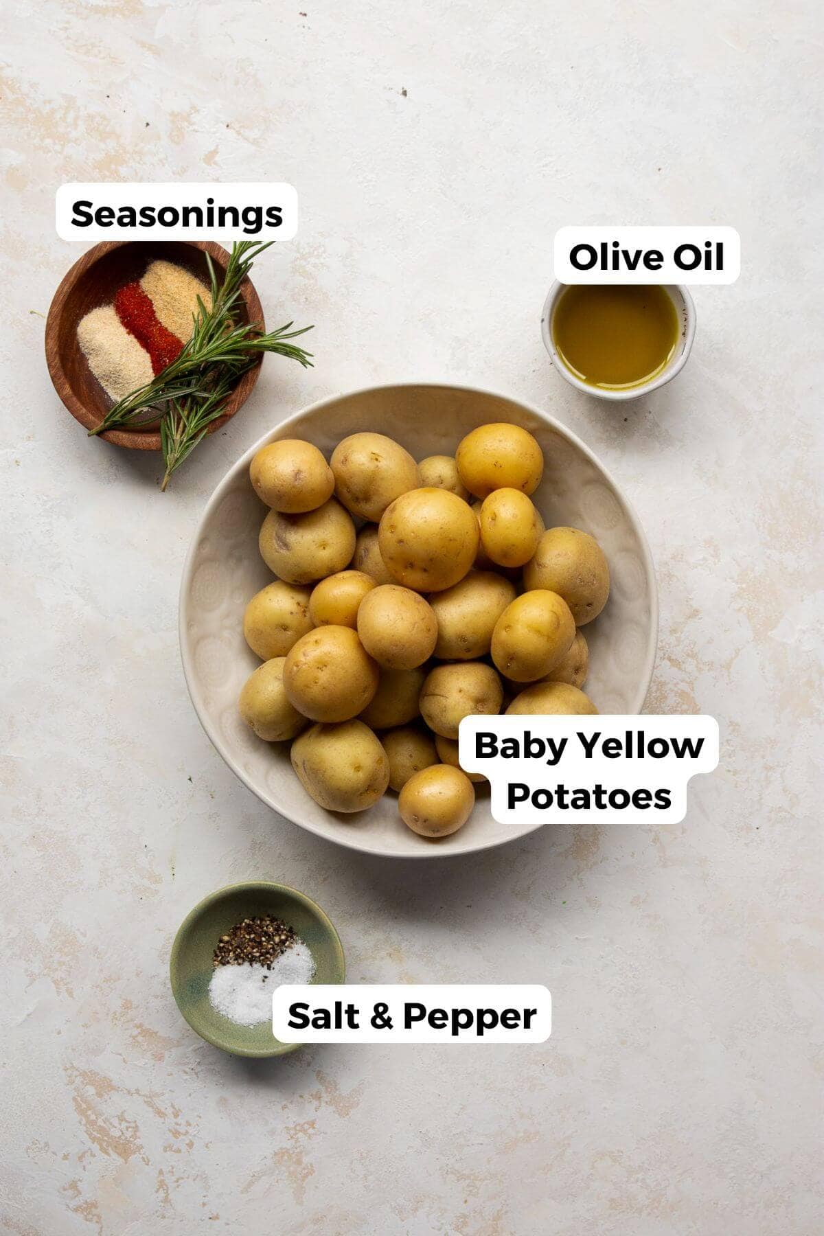 all ingredients in recipe including babay yellow potatoes, salt, pepper, olive poil, paprika, garlic power, onion powder, and rosemary