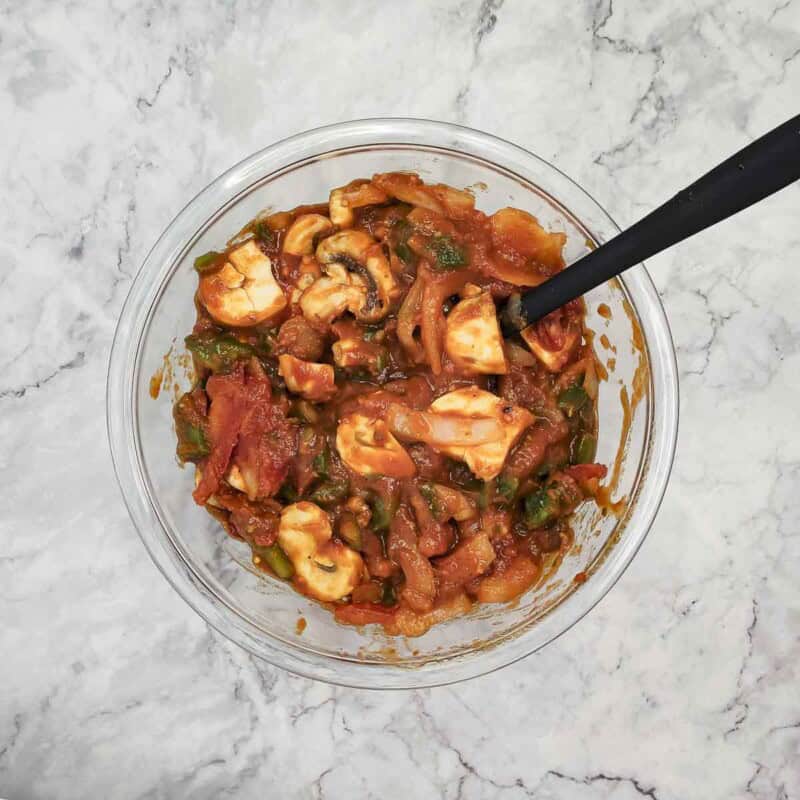 Overhead view of process shot 2 - combine the mixture until the veggies are well coated with the sauce.