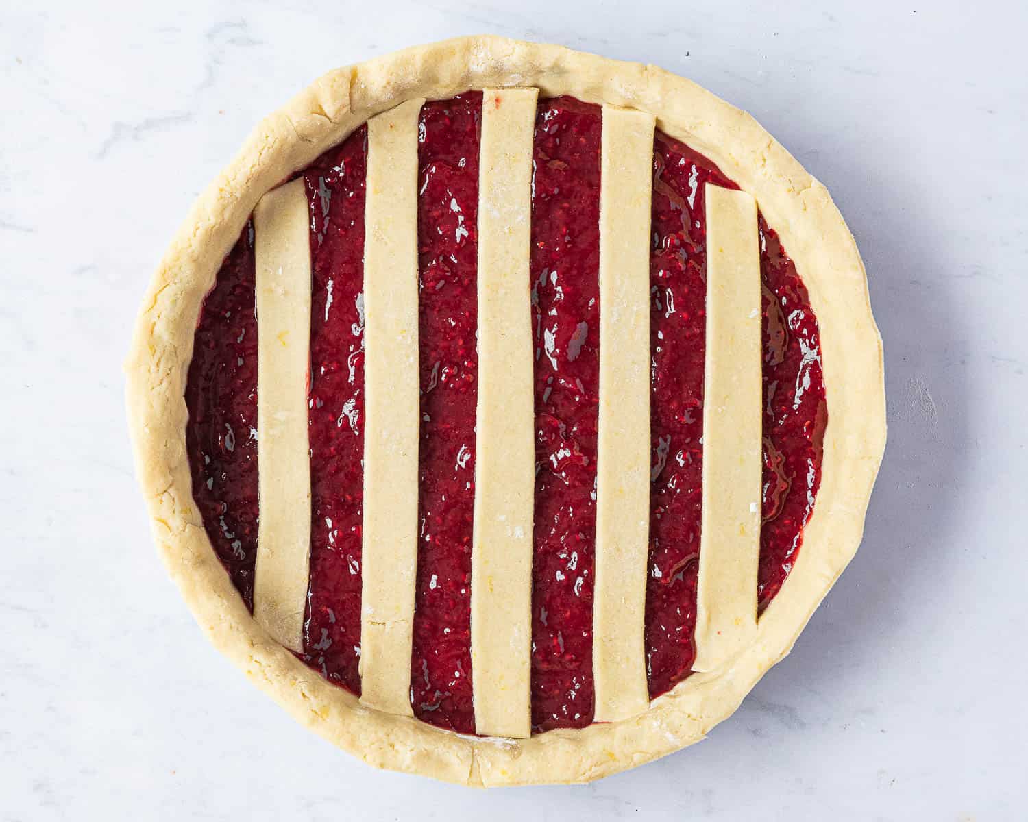 Step 5, the jam filled case with half of the lattice strips on top.