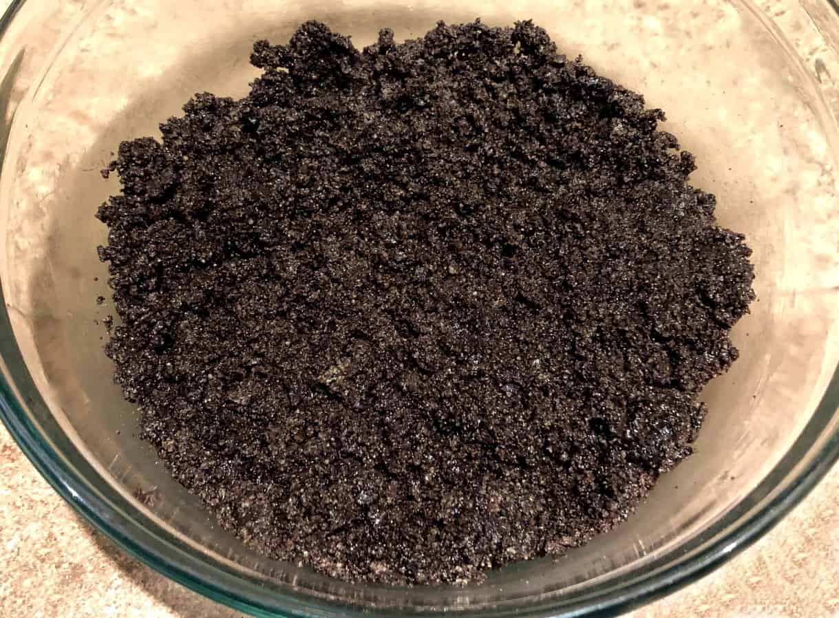 crushed oreos and butter in a bowl for pie crust.