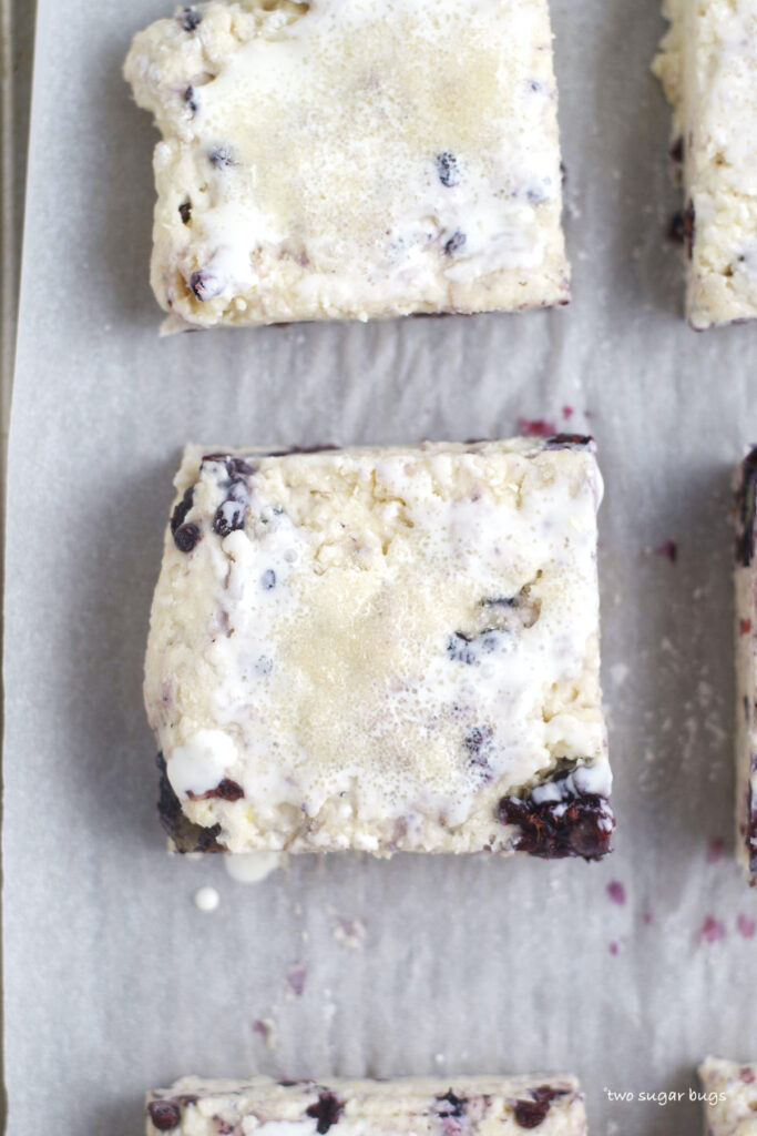 unbaked scones brushed with heavy cream and topped with sugar