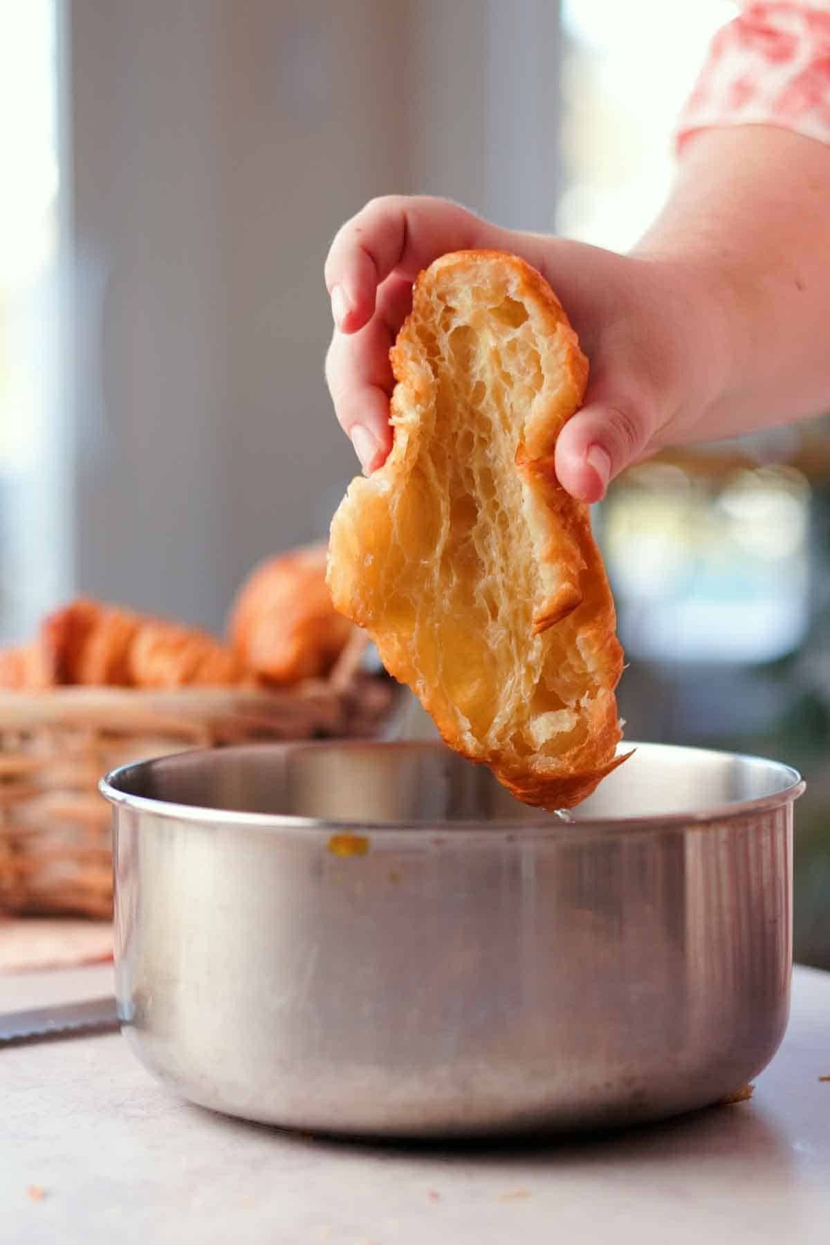 dipping croissants cut in half into syrup