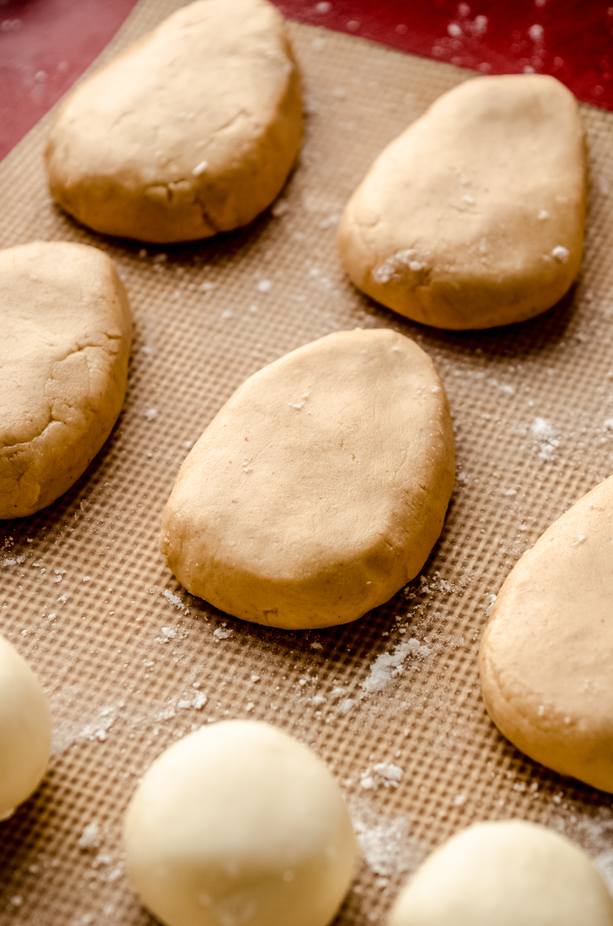 Peanut butter eggs shaped and on a baking sheet before getting dipped in chocolate.