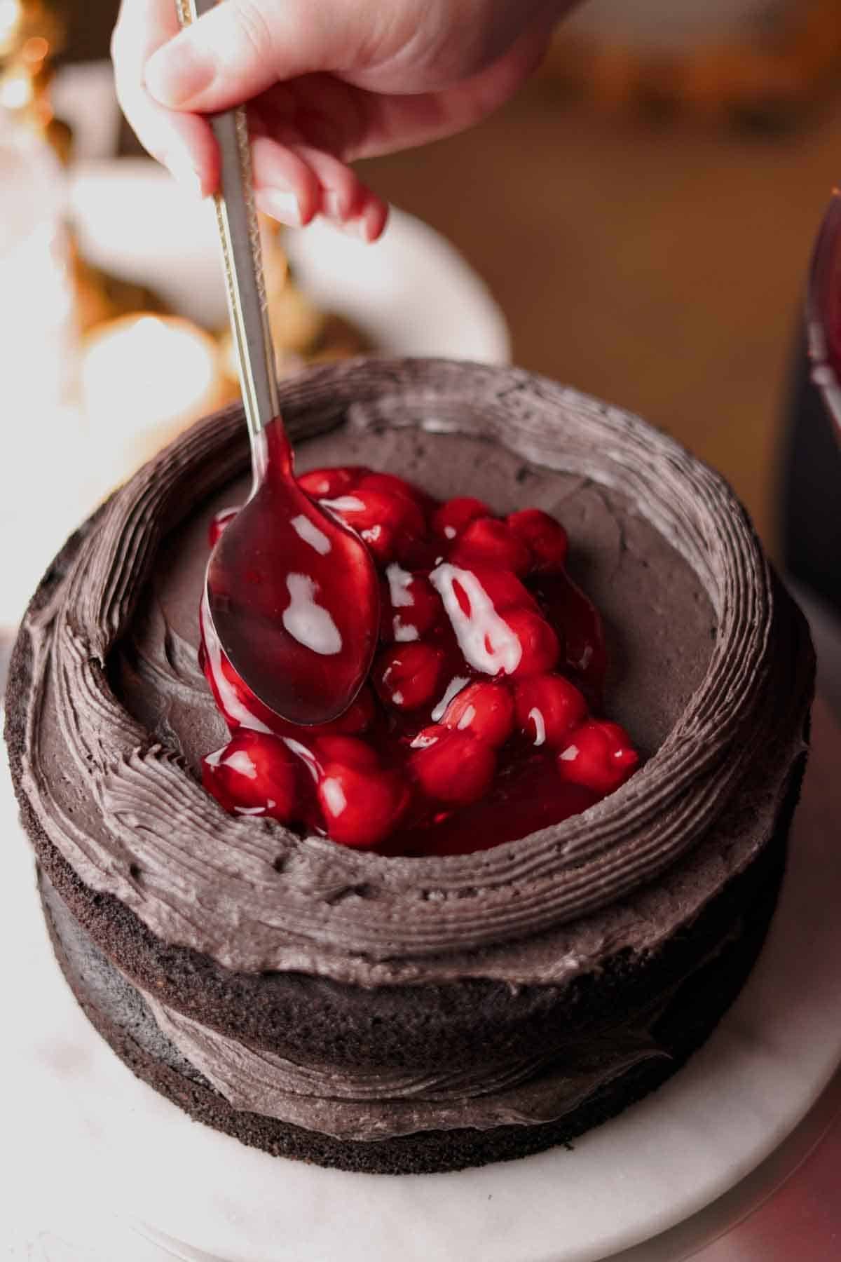 filling the cake with cherry filling while stacking layers