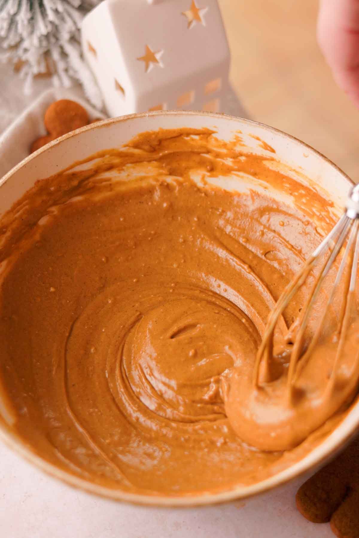 folding gingerbread batter with a handheld wire whisk