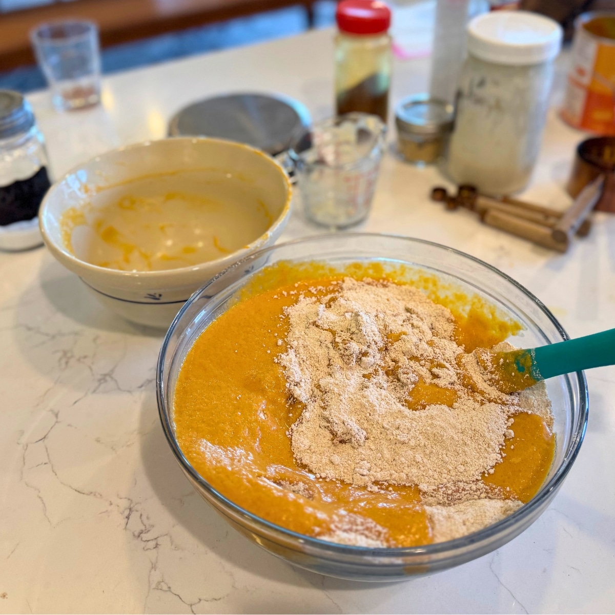 folding wet ingredients into dry ingredients with a rubber spatula separate bowls