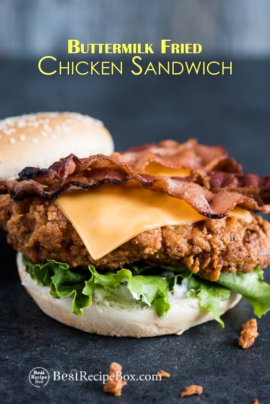 Fried Buttermilk Chicken Sandwich with Bacon & Cheddar on cutting board 