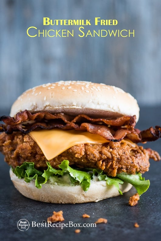Fried Buttermilk Chicken Sandwich with Bacon & Cheddar on cutting board 