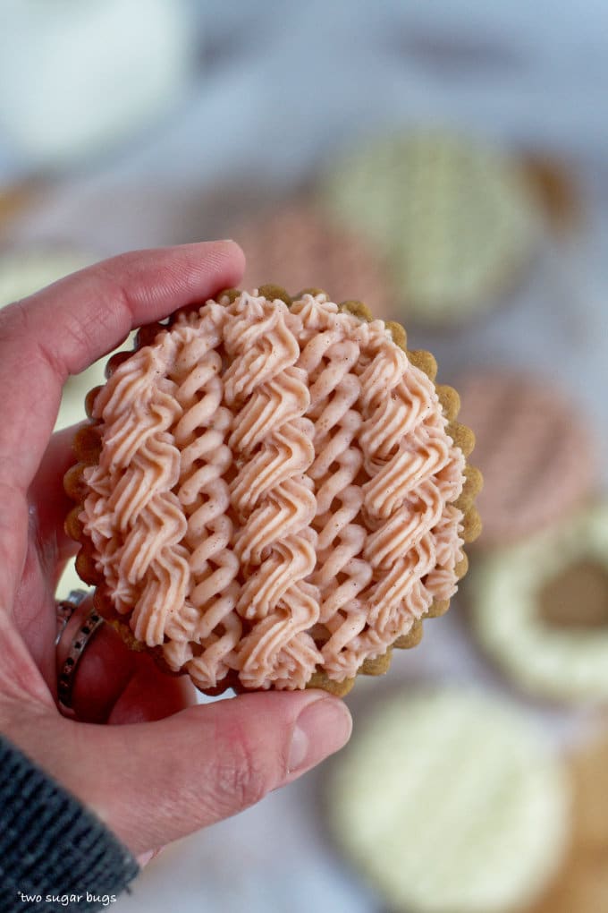 hand holding a cable knit sweater decorated sugar cookie