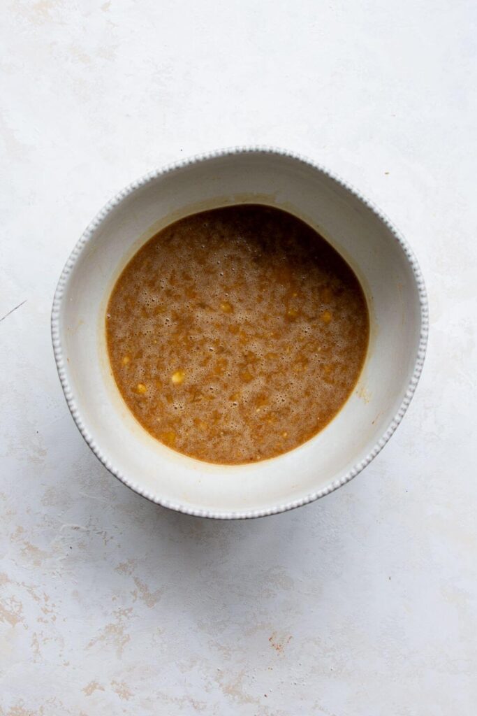 mashed banana, maple syrup, eggs, coconut oil, and vanilla whisked together in a bowl