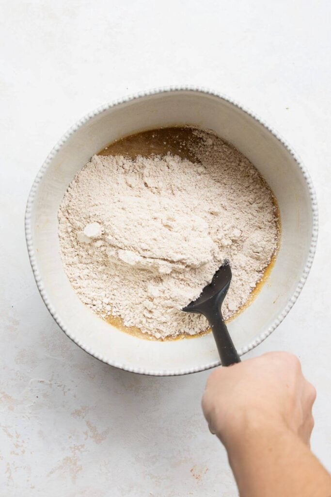 adding oat flour and almond flour to wet banana mixture