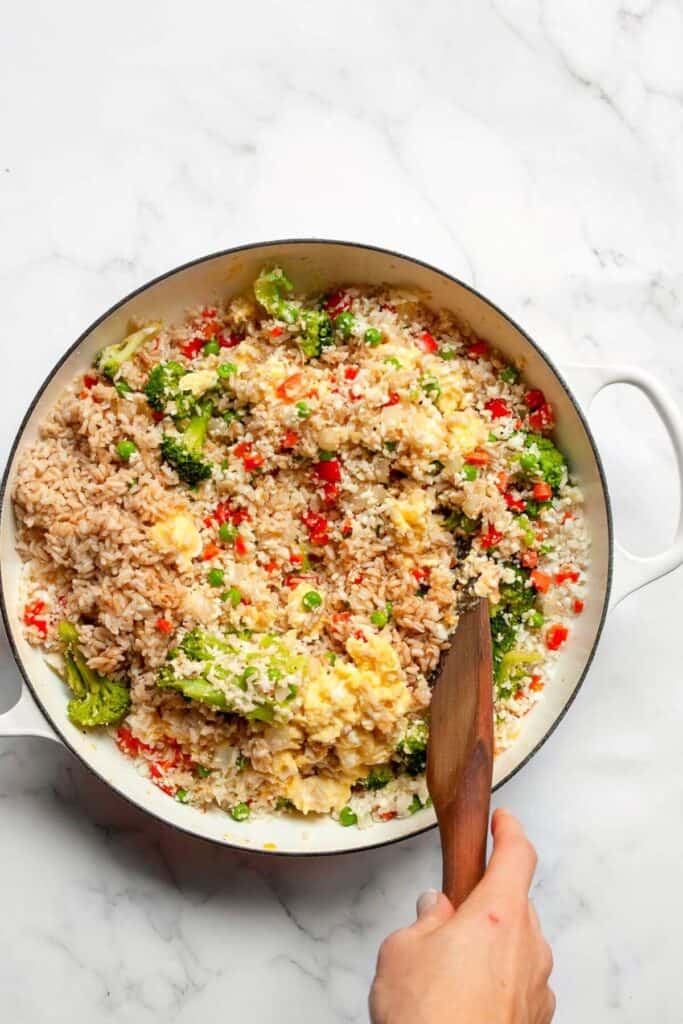 adding scrambled eggs to fried rice