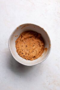 pumpkin muffin batter with chocolate chips in a mixing bowl