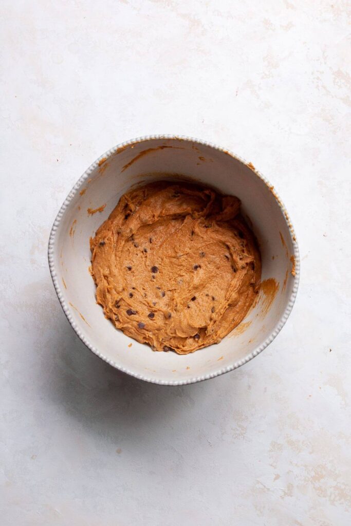 healthy pumpkin muffin batter with chocolate chips in a mixing bowl