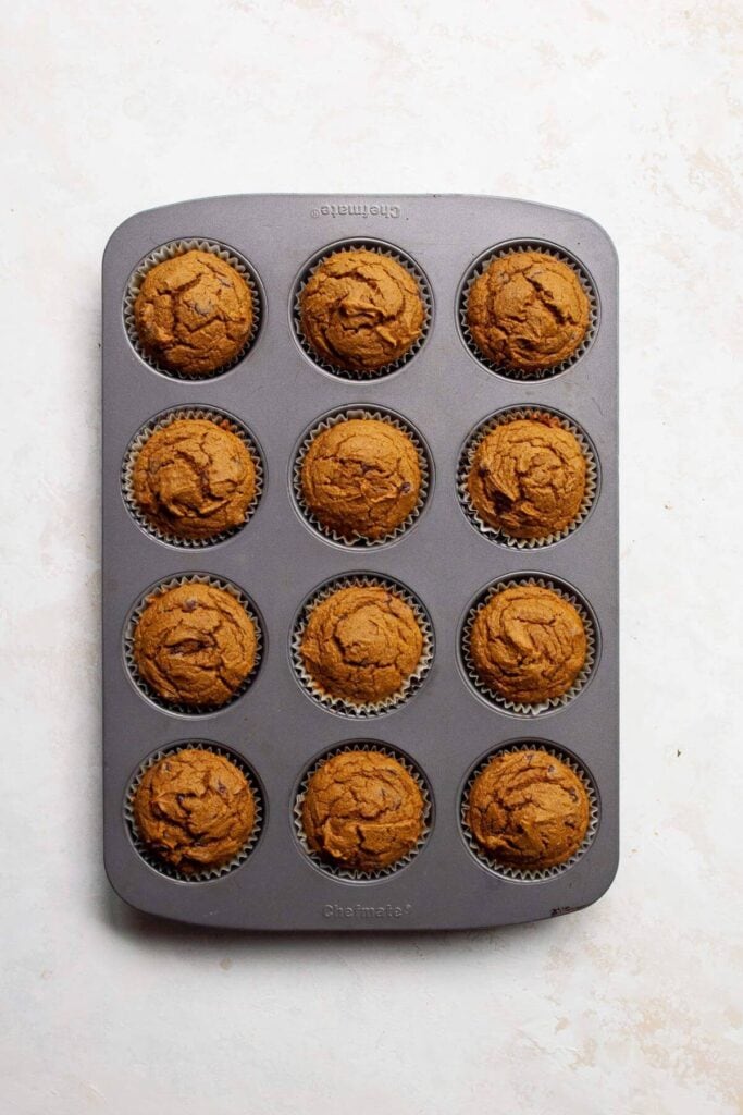 baked healthy pumpkin oat flour muffins in a cupcake tin