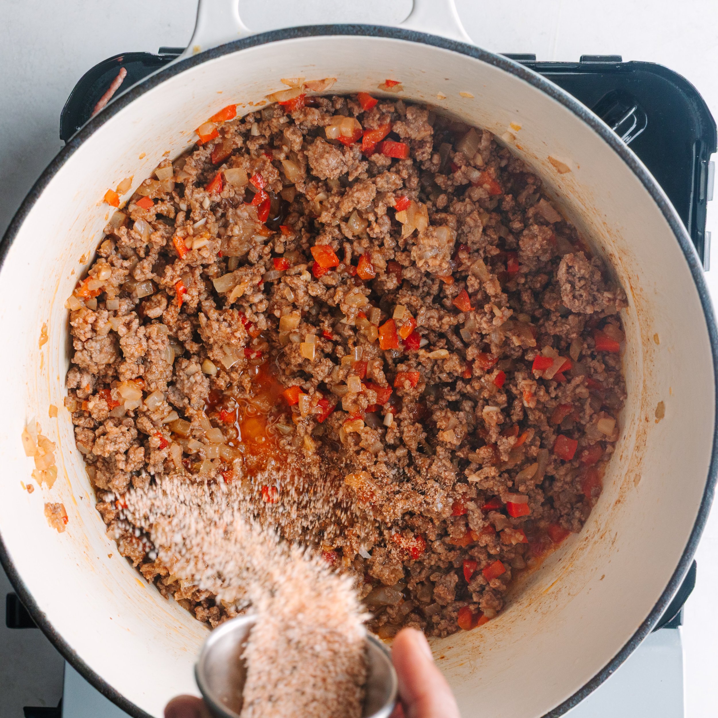 Adding tomato paste, soul dust, mustard, and Worcestershire sauce.