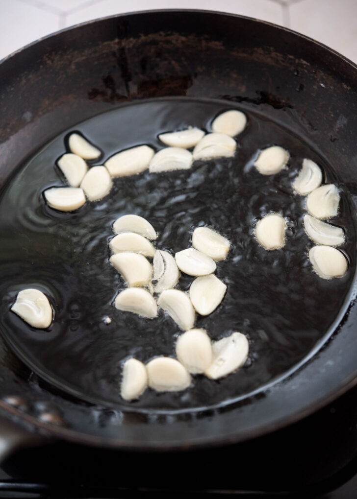 Garlic slices sizzling in oil in a skillet