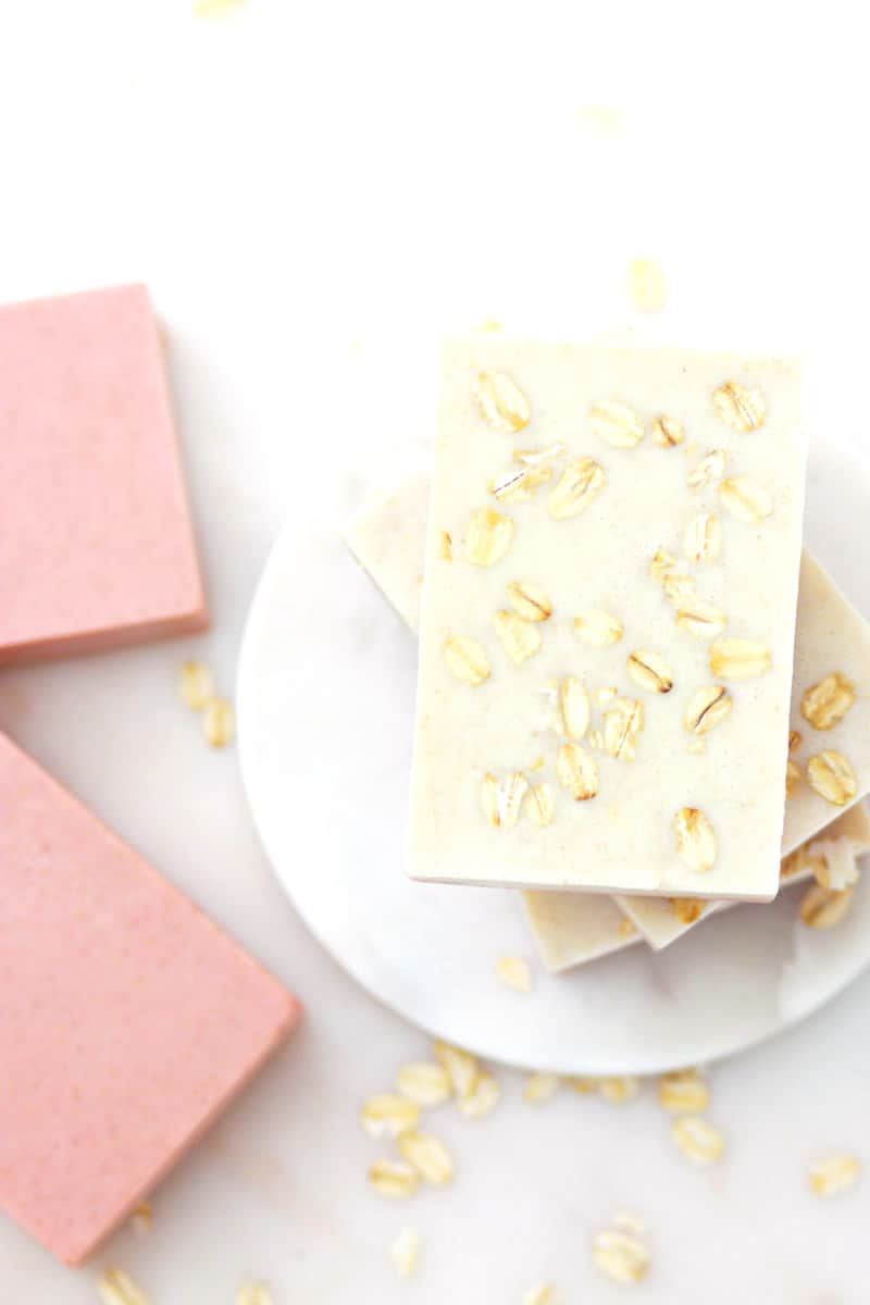 handmade oatmeal soaps with pink clay mixed in laying on a marble soap dish