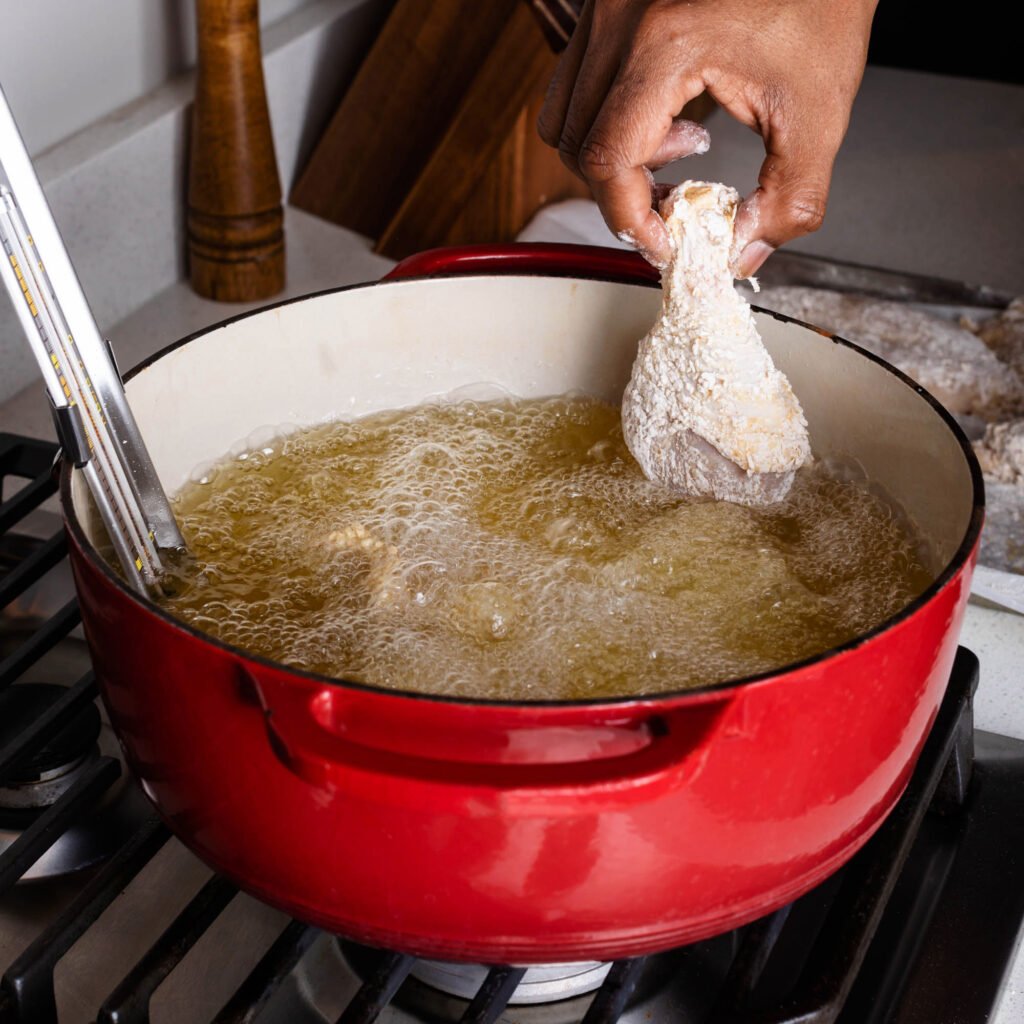 frying chicken in a large dutch oven