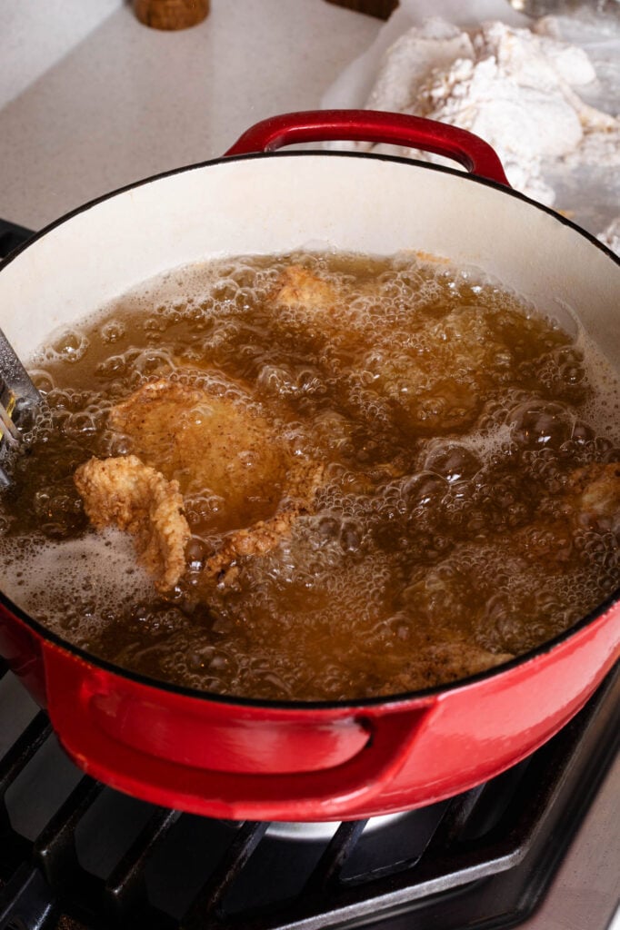 frying chicken in a large dutch oven