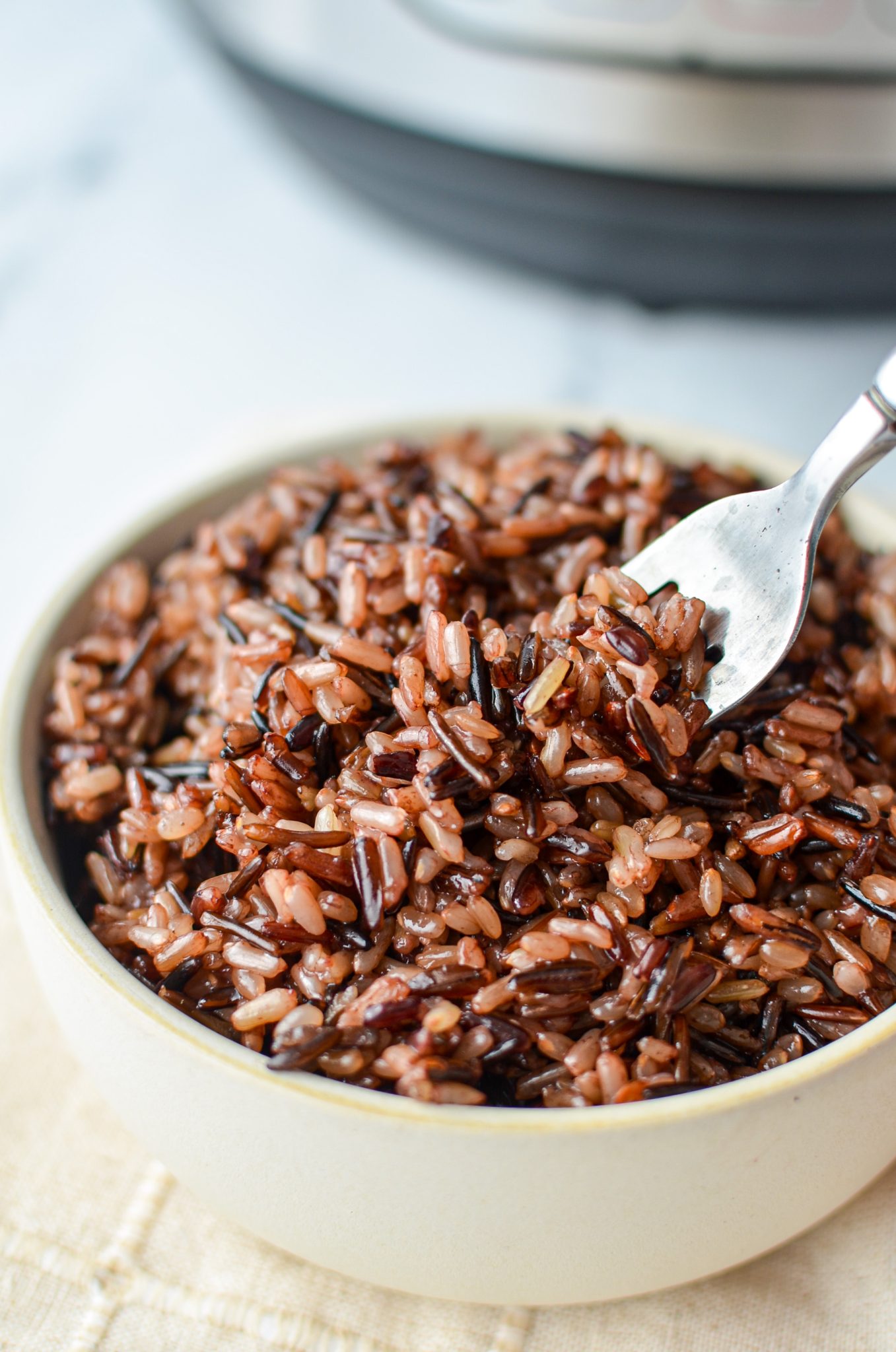 A bowl of rice, with a fork taking a portion.
