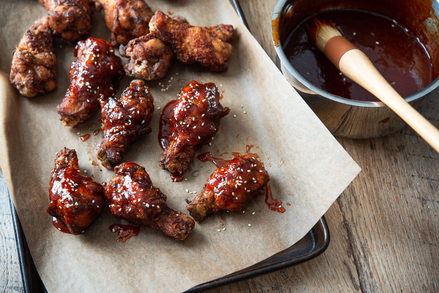 Fried chicken wings brushed with spicy red sauce.