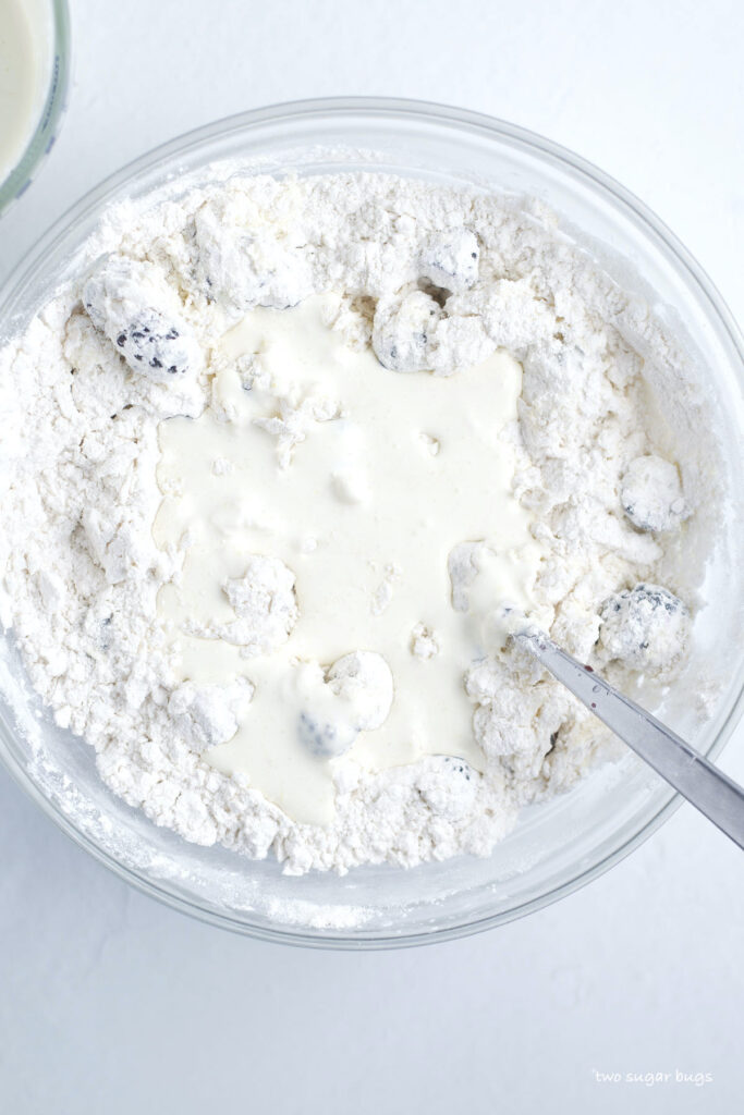 heavy cream poured over dry scone ingredients in a bowl