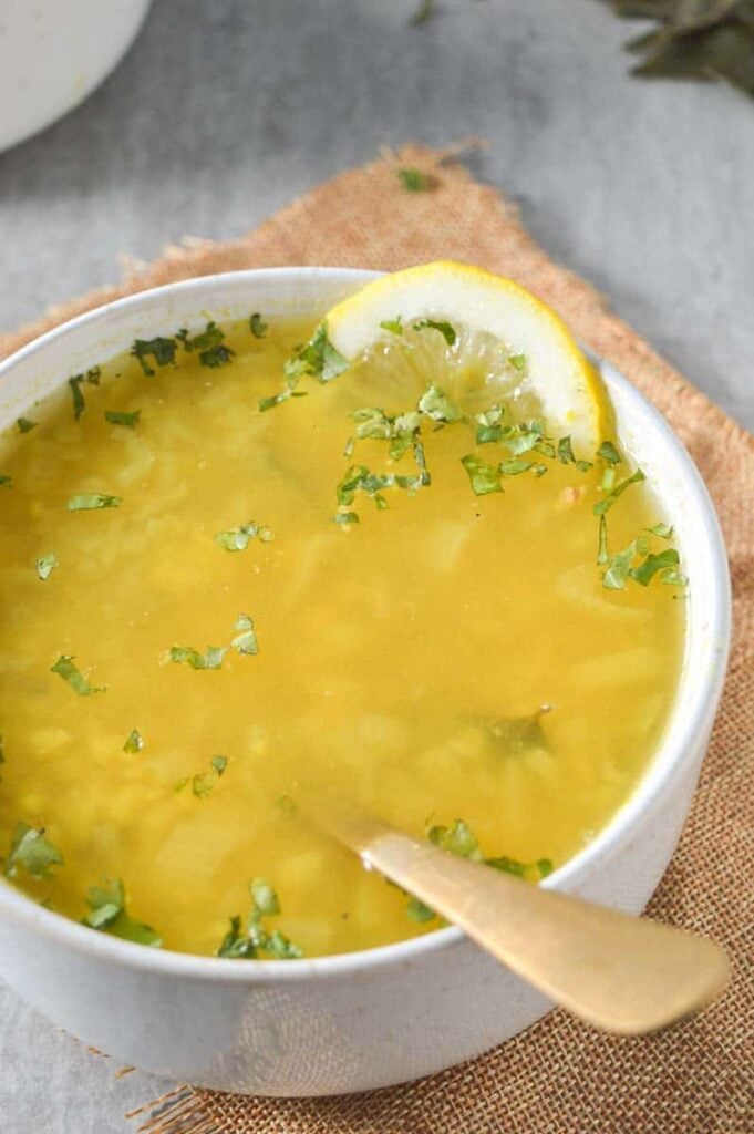 A bowl of yellow soup with fresh cilantro
