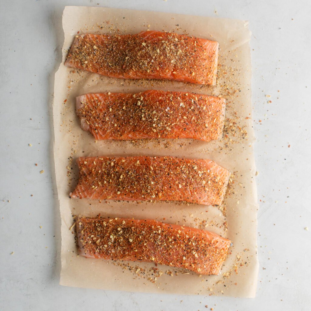 4 pieces of salmon seasoned with homemade lemon pepper seasoning and kosher salt. 