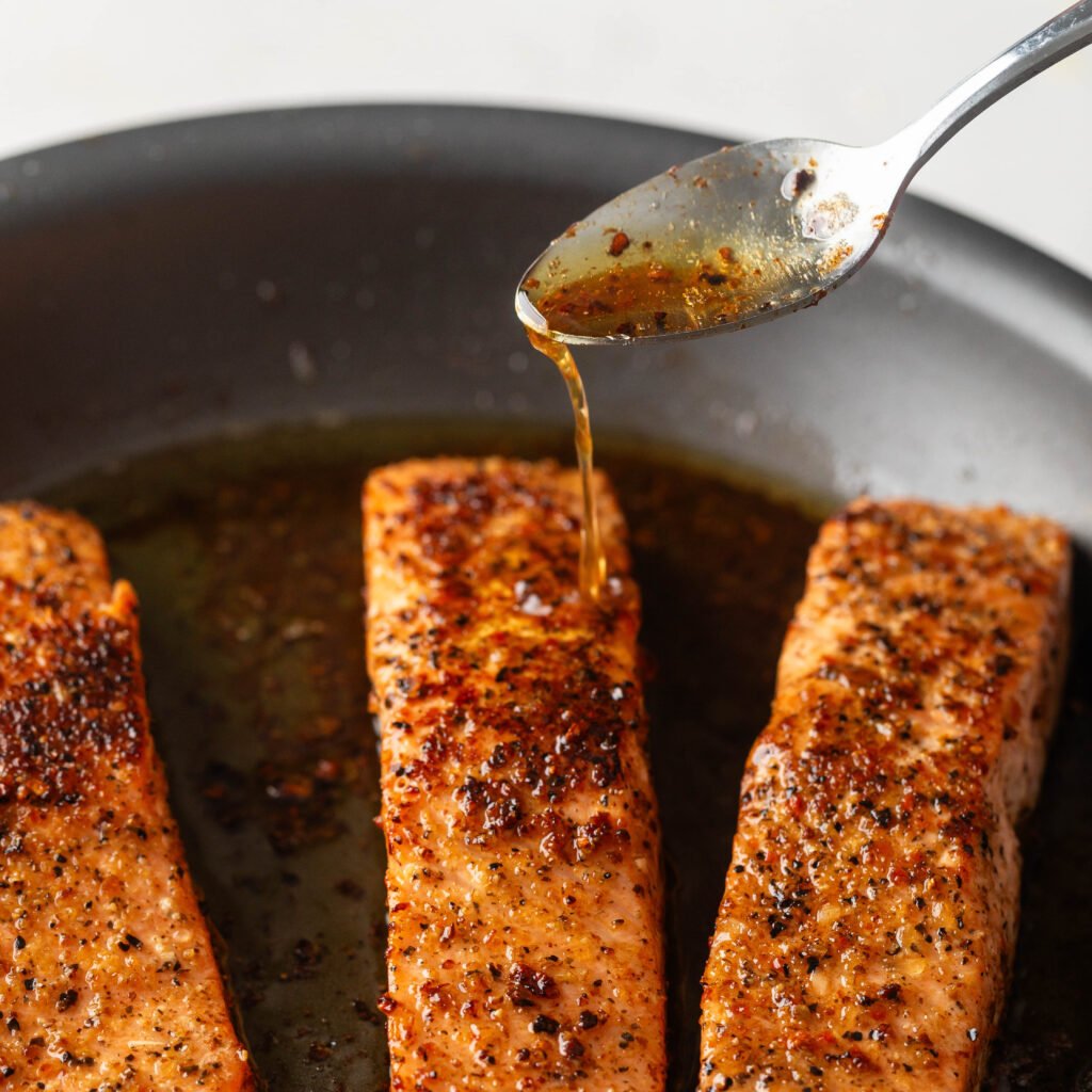 Basting salmon with pain juices. 