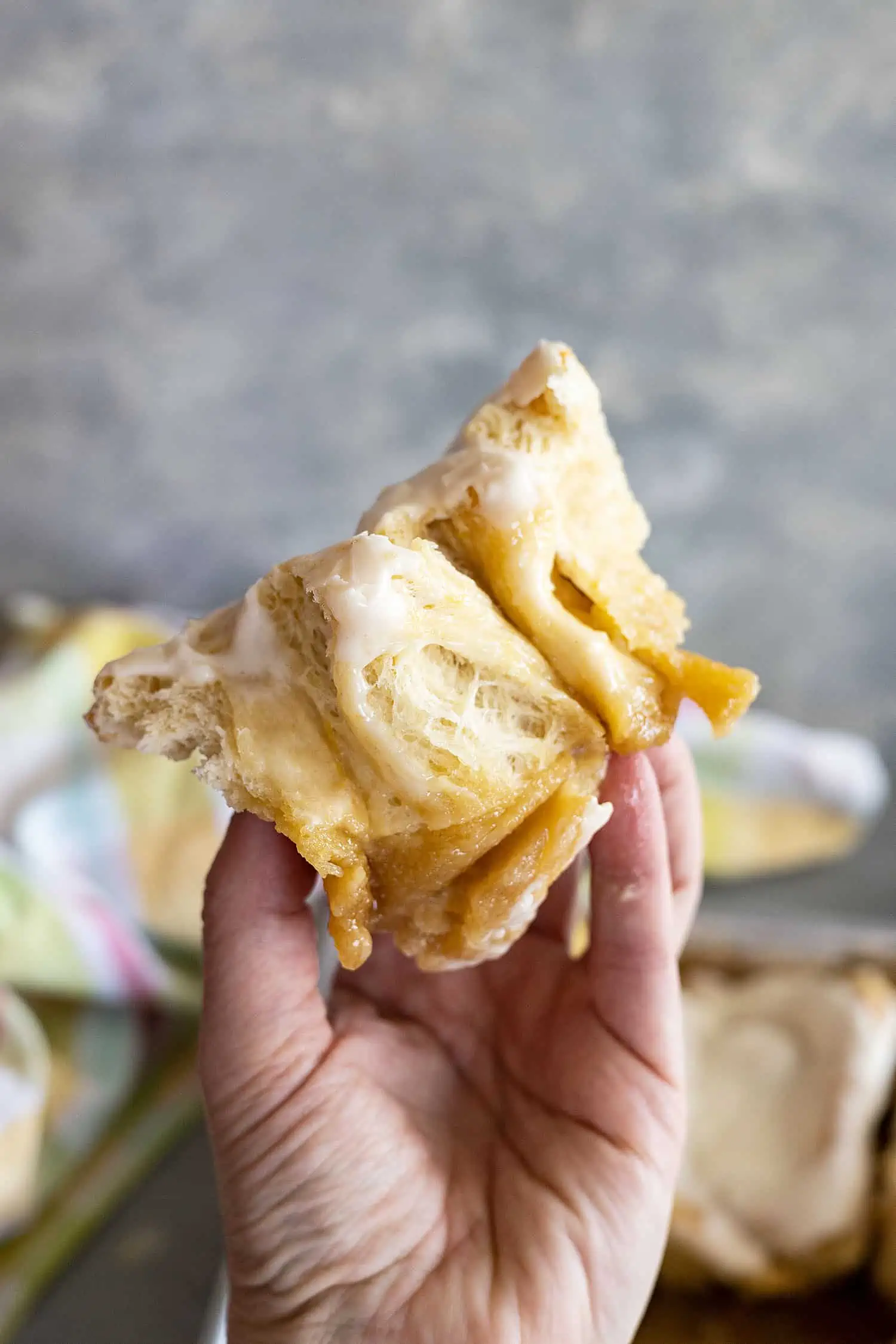 A hand holding up a roll cut in half to show the yummy fluffy interior.