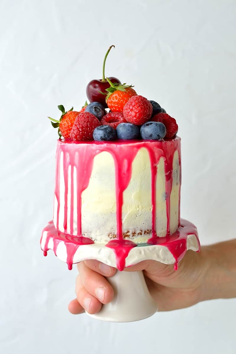 Mini white chocolate berry drip cake - delicious, moist vanilla cake with whipped white chocolate gananche, pink white chocolate drip and fresh berries; serves just 2-4 people!