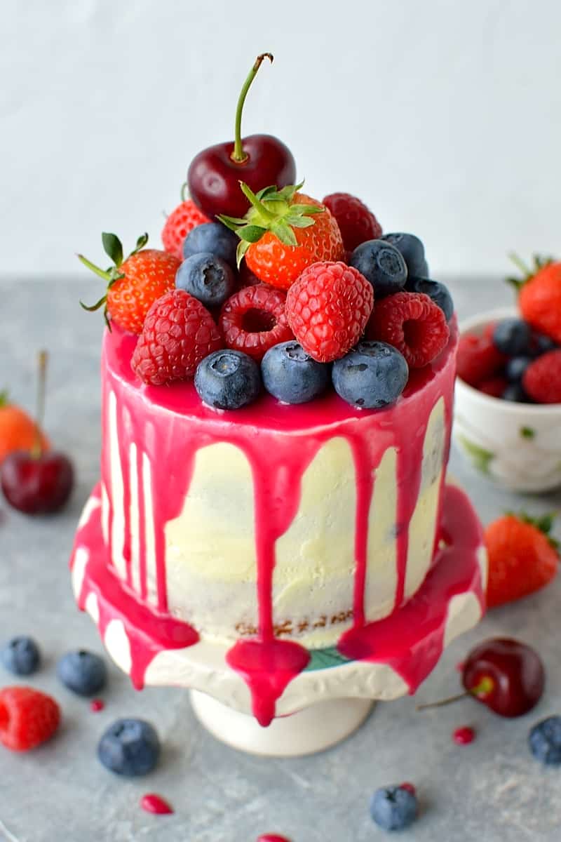Mini white chocolate berry drip cake - delicious, moist vanilla cake with whipped white chocolate gananche, pink white chocolate drip and fresh berries; serves just 2-4 people!