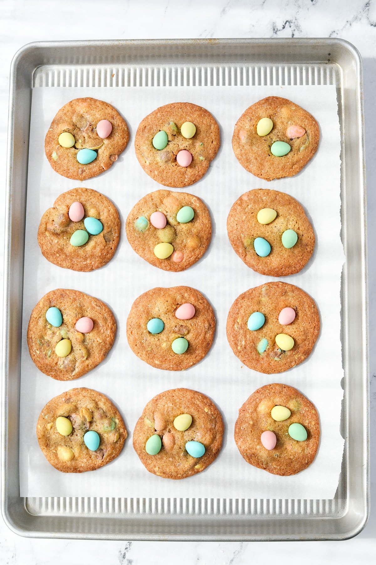 A baking sheet with mini egg cookies on it.