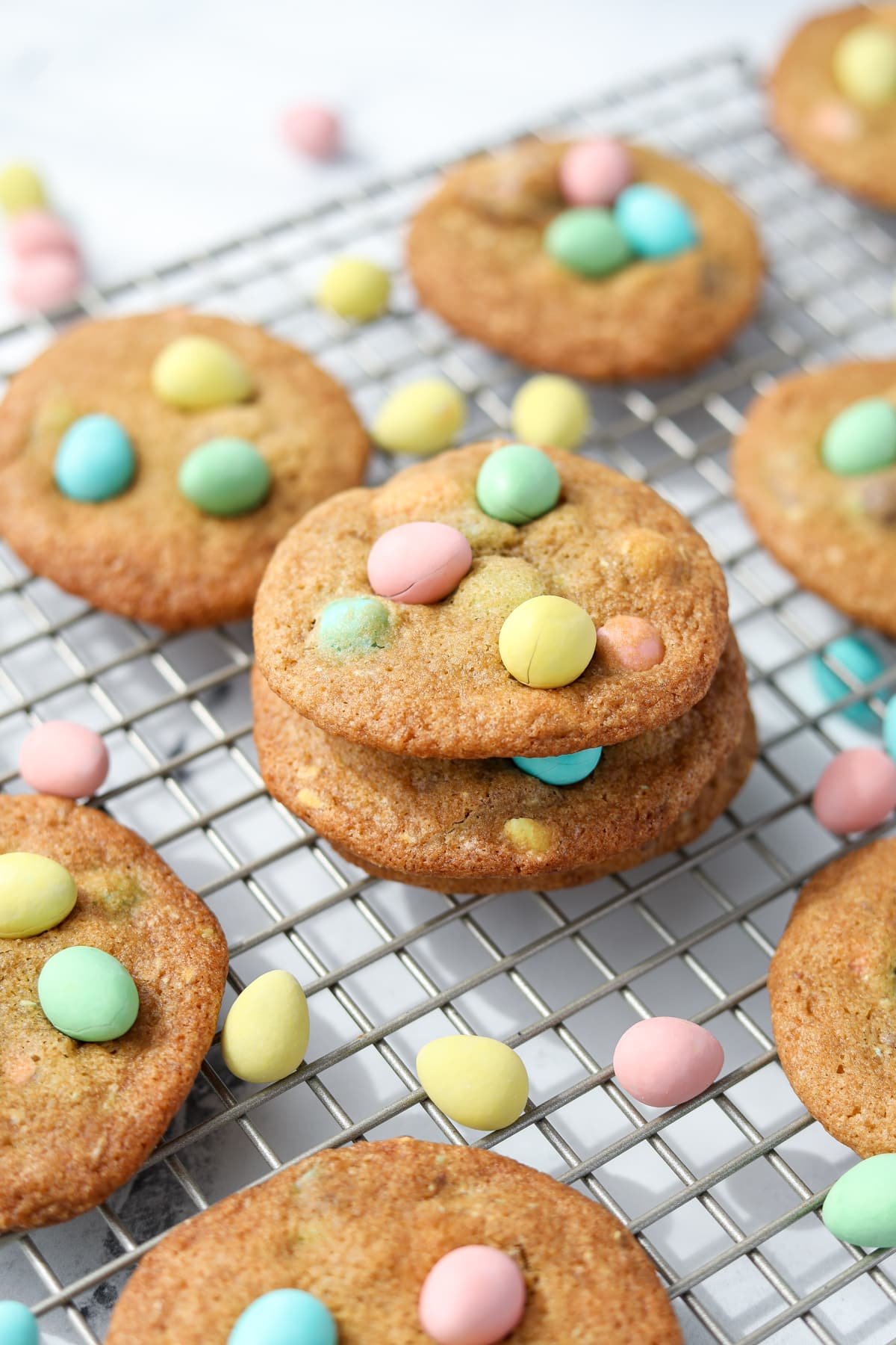 Homemade cookies on a wire rack, topped with Cadbury mini eggs.
