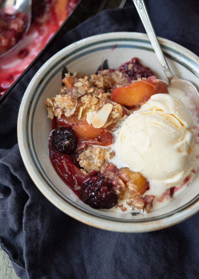 Serve warm nectarine blackberry crisp with vanilla ice cream
