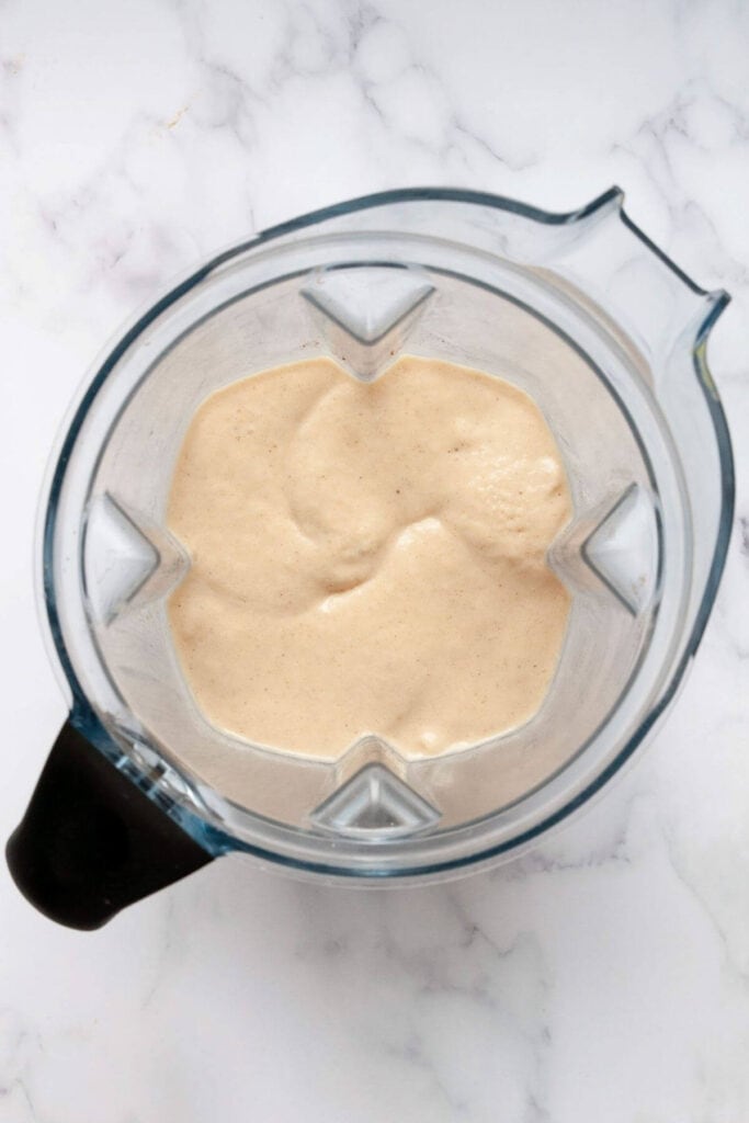 blended oat milk smoothie in a blender to show thick, creamy texture