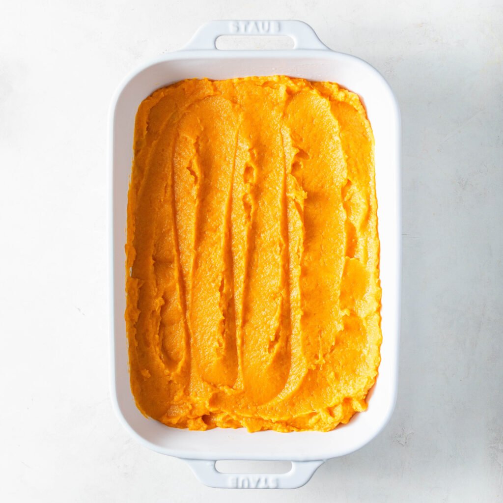 Old fashioned sweet potato casserole in a white staub casserole dish