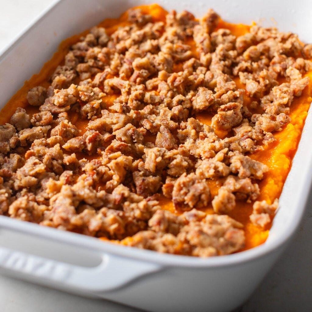 Old fashioned sweet potato casserole with streusel topping in a white casserole dish