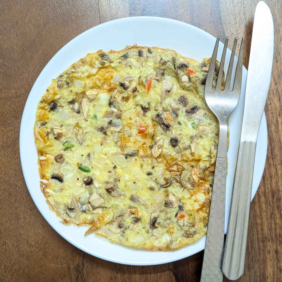 Mushroom omelette in air fryer served on a white plate.