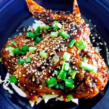 Crispy Baked Asian Chicken Wings on a plate with chopped green onions and baked sesame seeds for garnish.