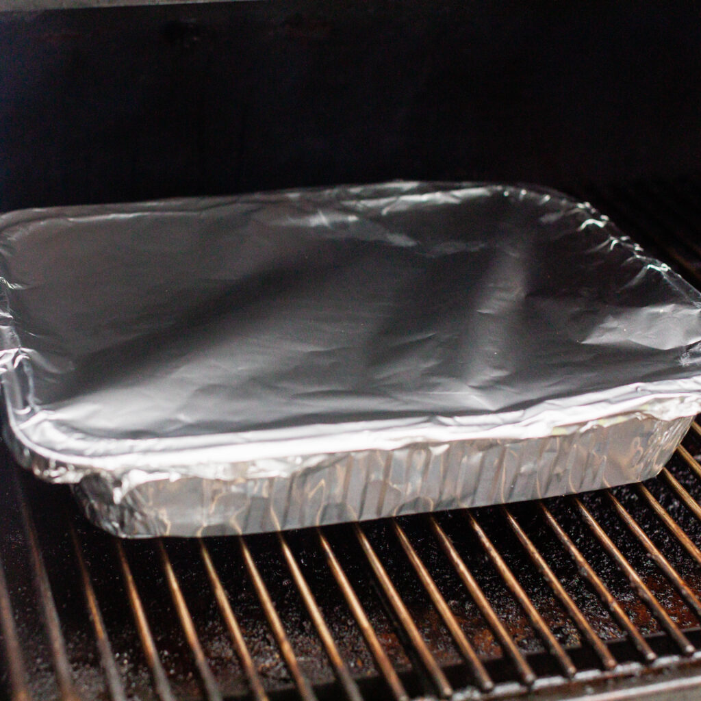 pan of ribs wrapped in foil back on the smoker