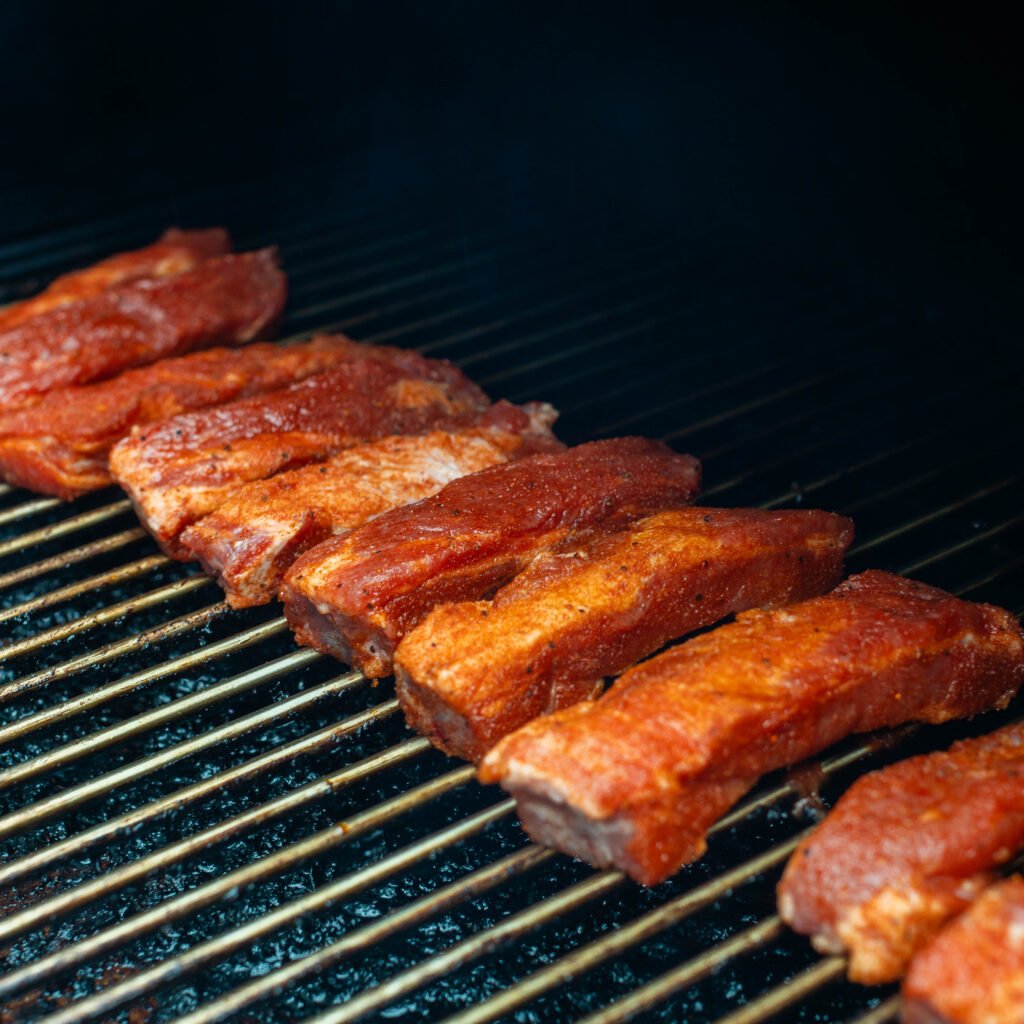 seasoned ribs on grill grates.