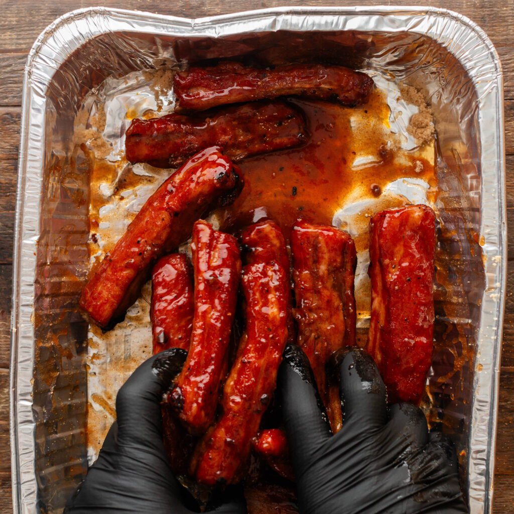 smoked ribs placed in aluminum pan