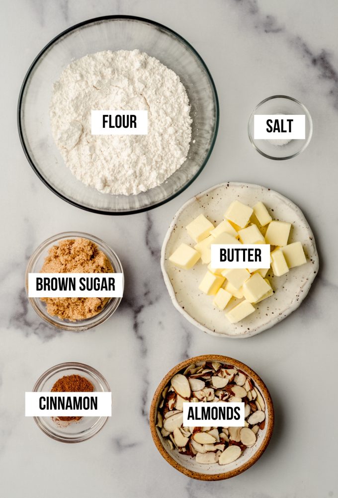Aerial photo of ingredients to make almond streusel muffins with text overlay labeling each ingredient.