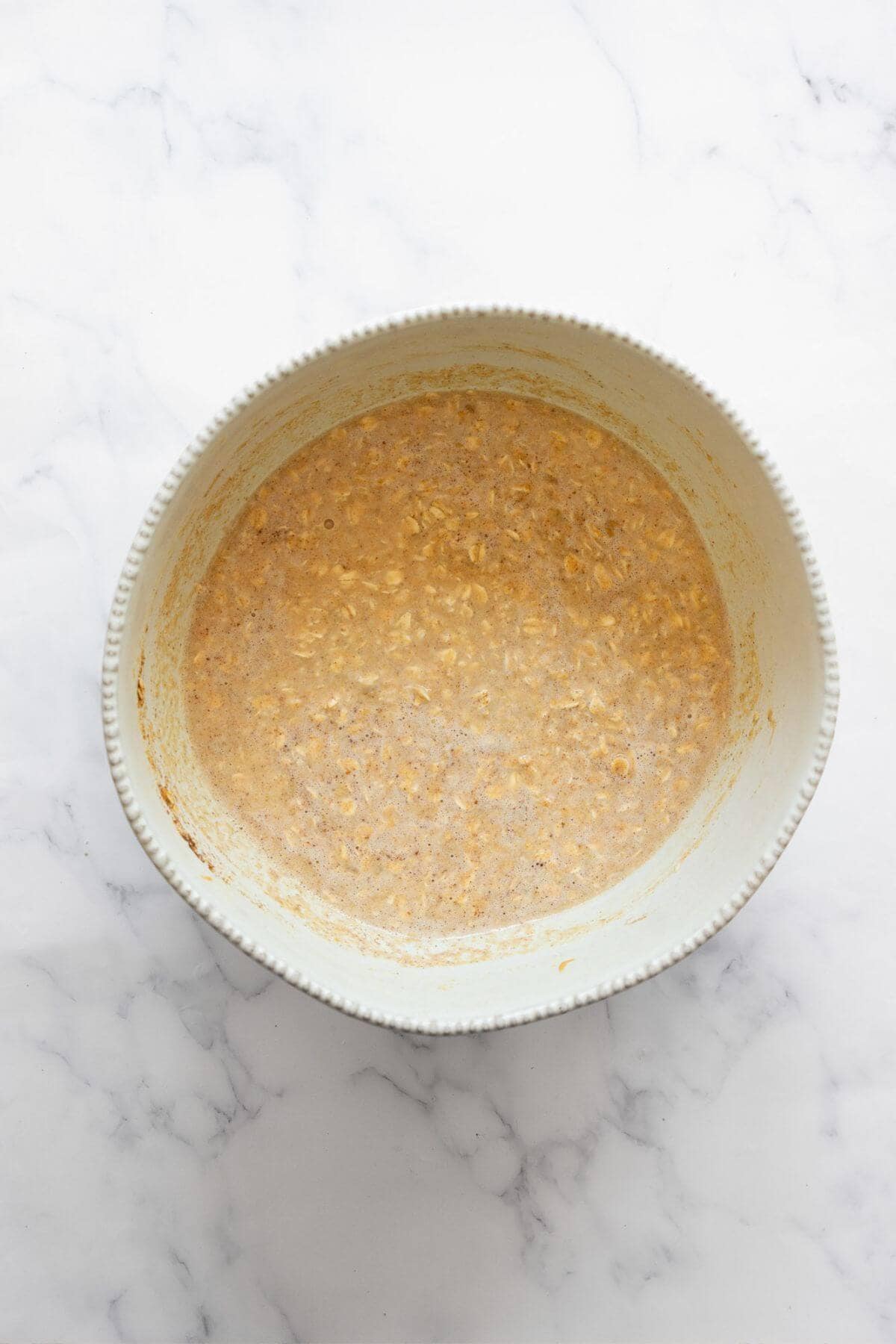 Peanut butter banana baked oatmeal batter mixed in a large bowl, ready to be poured into the baking dish.