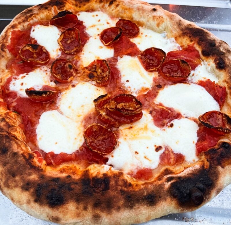 pepperoni pizza cooked in an ooni oven with poolish pizza dough