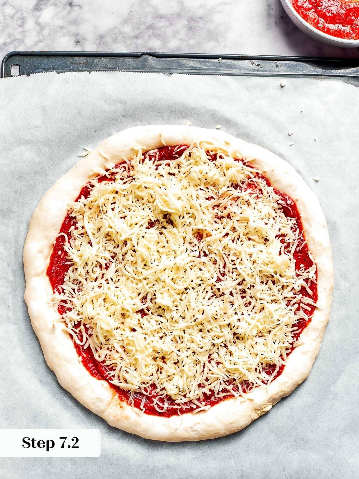Cheese evenly distributed on top of unbaked pizza crust.